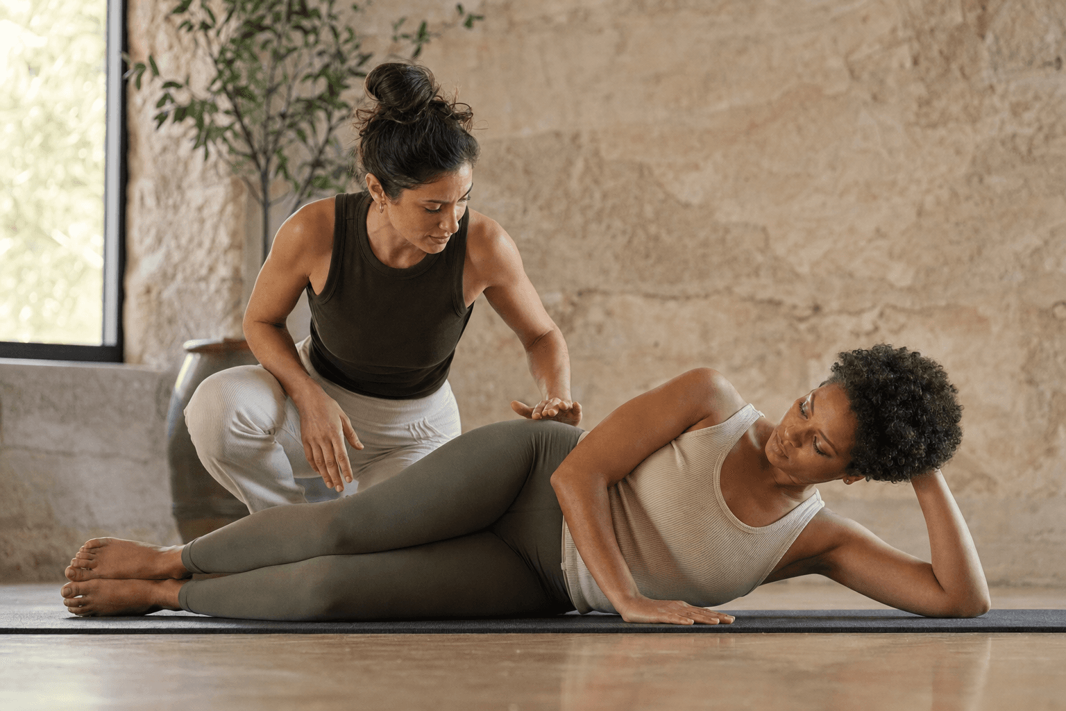 Instructor observing a student in neutral spine alignment on a mat